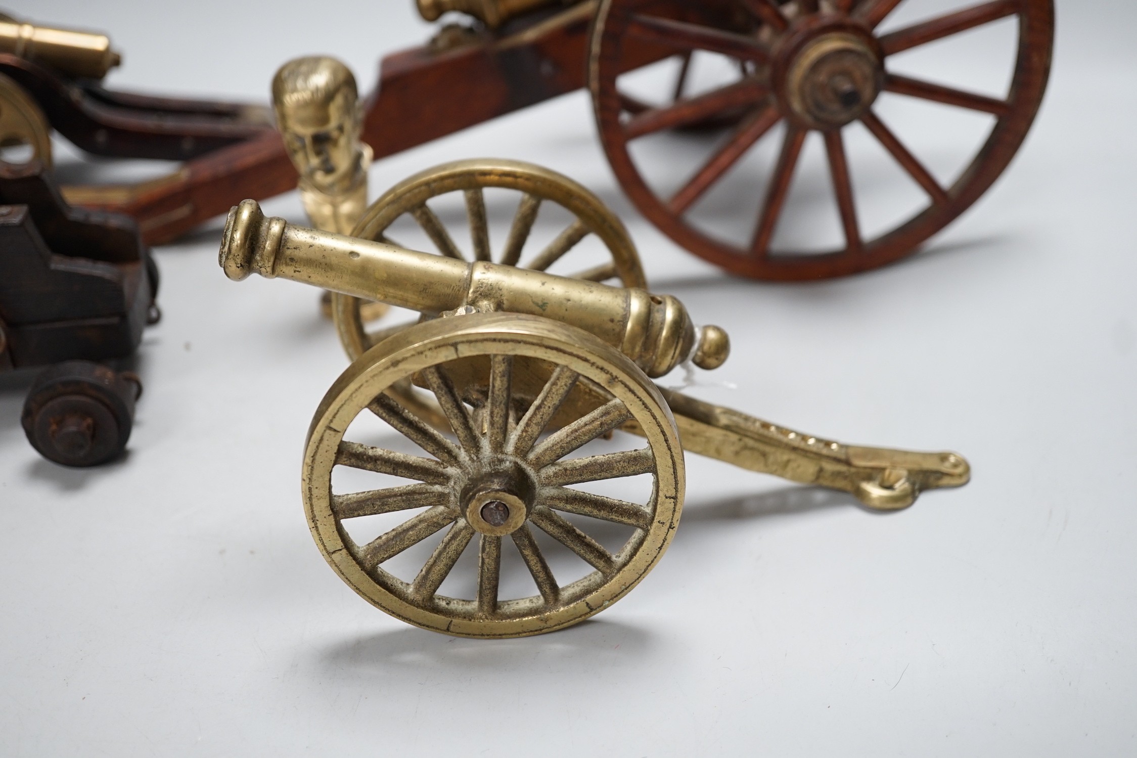 A bronze 'Napoleon bust' desk seal, 8.5cm tall, together with four models of cannons. Largest 39cm wide